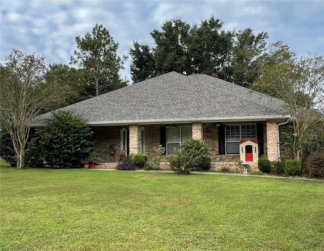 single story home with brick siding, a front lawn, covered porch, and roof with shingles