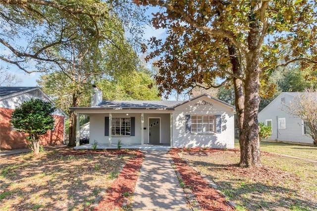 view of front of house with covered porch and a chimney