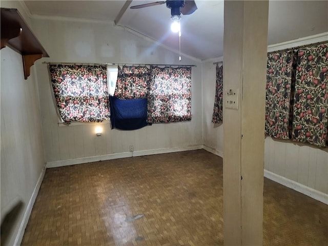 empty room with ceiling fan, crown molding, parquet floors, and vaulted ceiling