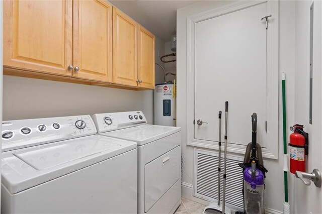 laundry room with independent washer and dryer, cabinet space, and electric water heater