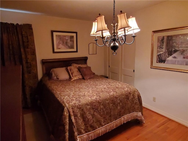 bedroom featuring hardwood / wood-style flooring and a notable chandelier