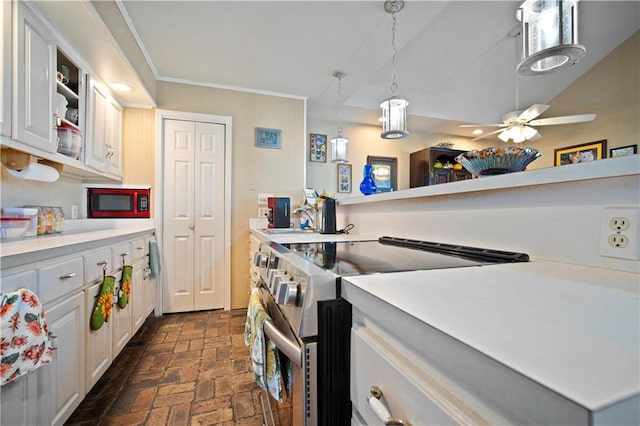 kitchen featuring ceiling fan, hanging light fixtures, stainless steel range, and white cabinets