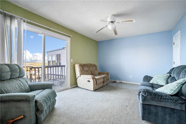 living room with ceiling fan, a textured ceiling, and light colored carpet