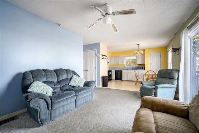 living room with ceiling fan with notable chandelier, a textured ceiling, sink, and light colored carpet