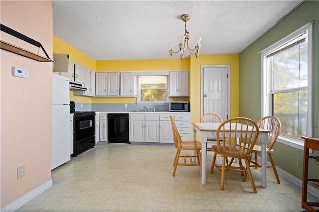 kitchen with black appliances, sink, plenty of natural light, and pendant lighting