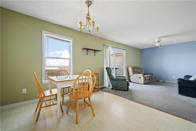 dining room featuring light carpet, a textured ceiling, and ceiling fan with notable chandelier