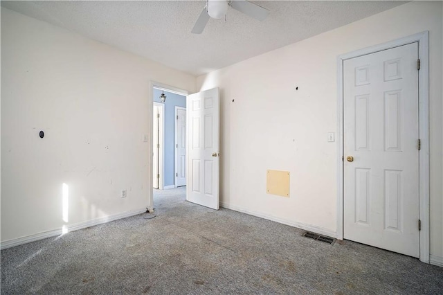 unfurnished room featuring a textured ceiling, carpet floors, and ceiling fan