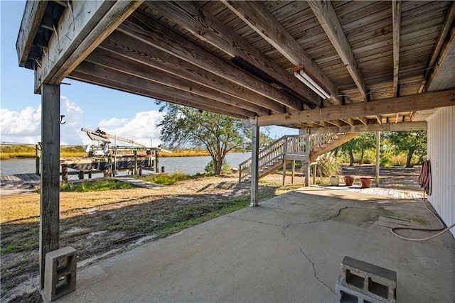 view of patio featuring a water view and a boat dock