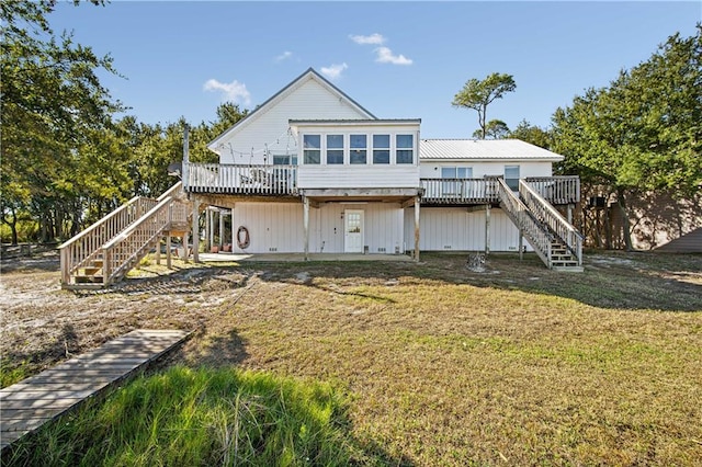 back of house featuring a deck and a lawn