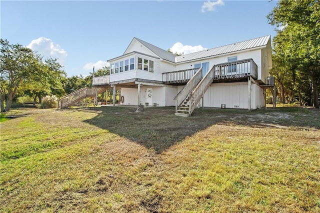 back of house featuring a deck and a yard