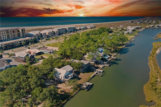 aerial view at dusk featuring a water view