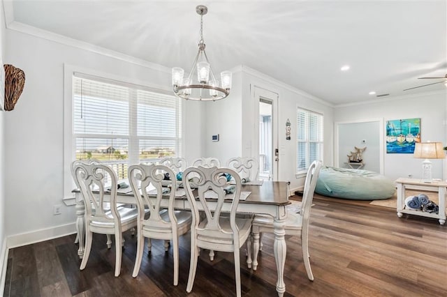 dining area featuring hardwood / wood-style flooring, ornamental molding, and ceiling fan with notable chandelier