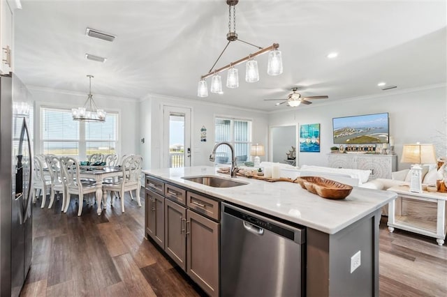 kitchen with sink, ornamental molding, an island with sink, pendant lighting, and stainless steel appliances