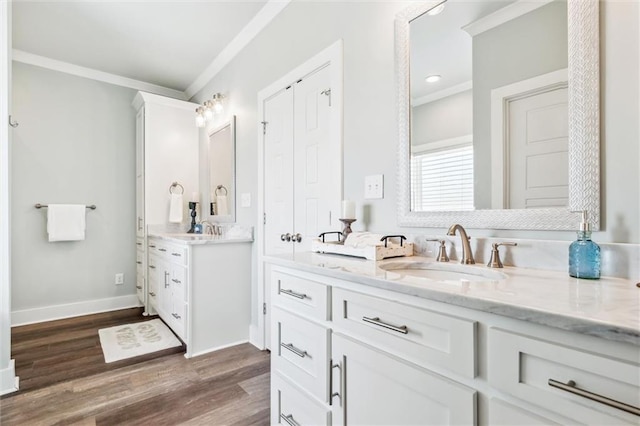 bathroom featuring hardwood / wood-style flooring, ornamental molding, and vanity