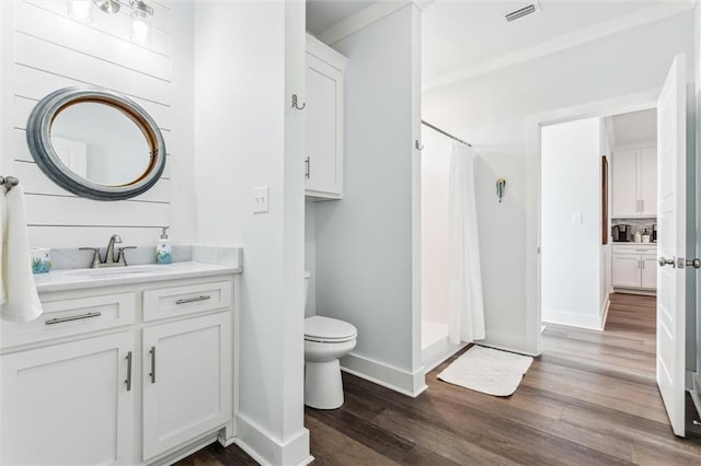 bathroom featuring walk in shower, vanity, toilet, and hardwood / wood-style floors