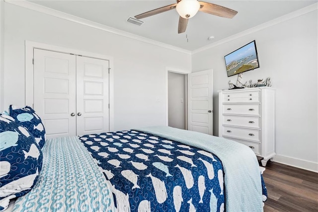 bedroom with ornamental molding, dark wood-type flooring, ceiling fan, and a closet