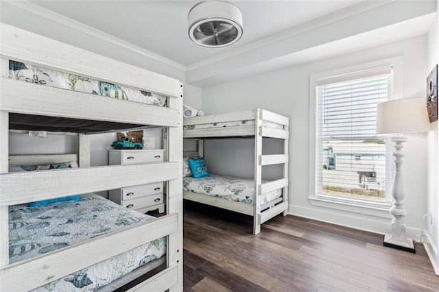 bedroom with dark wood-type flooring, ornamental molding, and multiple windows