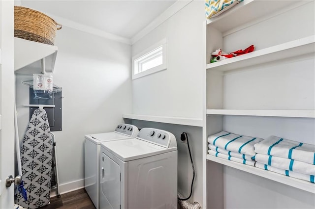 laundry area featuring crown molding, independent washer and dryer, and dark hardwood / wood-style floors