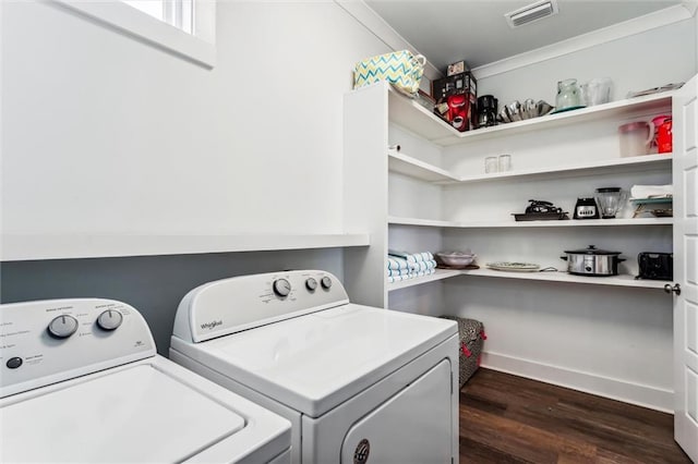 clothes washing area with dark hardwood / wood-style floors and washer and dryer