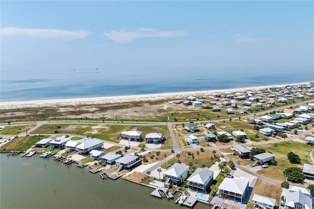 birds eye view of property with a water view and a beach view