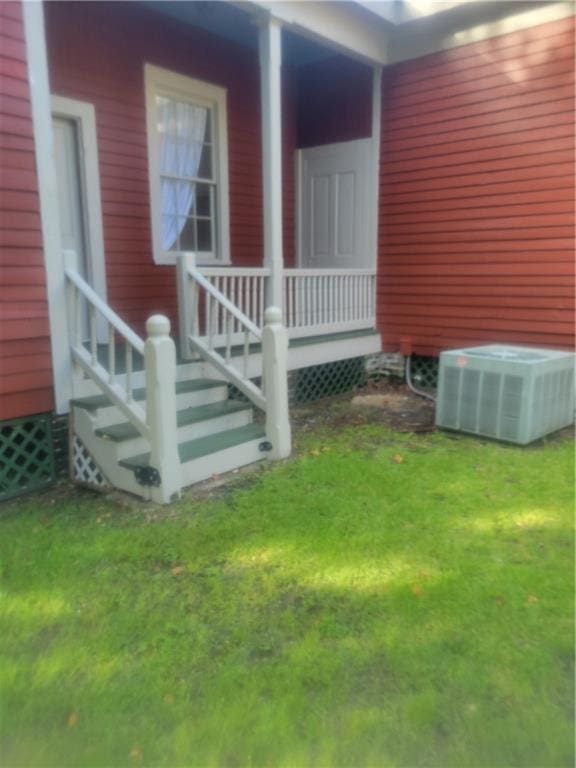 exterior space featuring central AC unit and a lawn