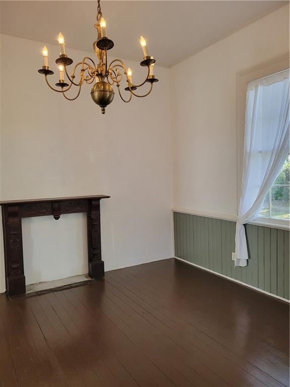 empty room featuring dark hardwood / wood-style flooring and a chandelier