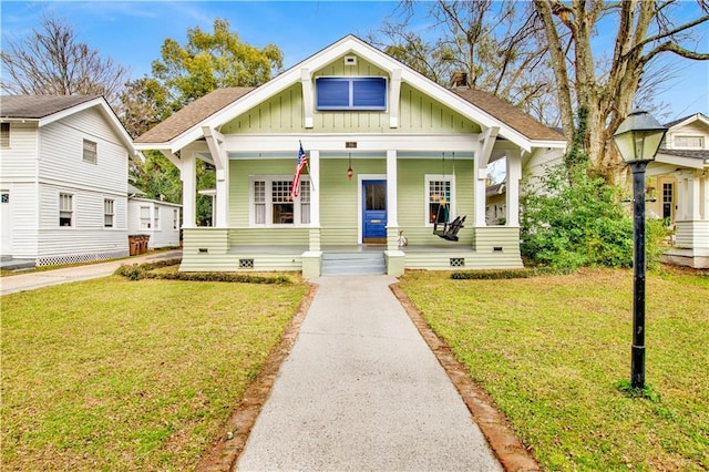 bungalow-style home with crawl space, a porch, board and batten siding, and a front yard