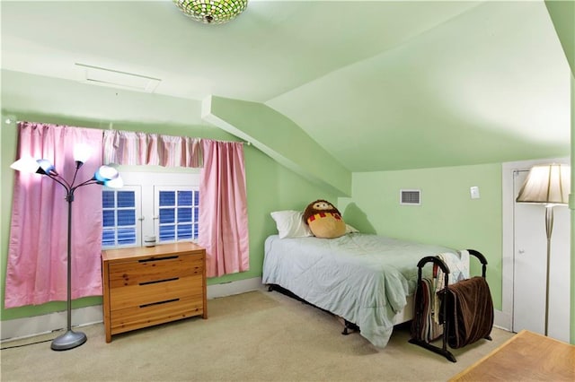 carpeted bedroom with vaulted ceiling, visible vents, and attic access