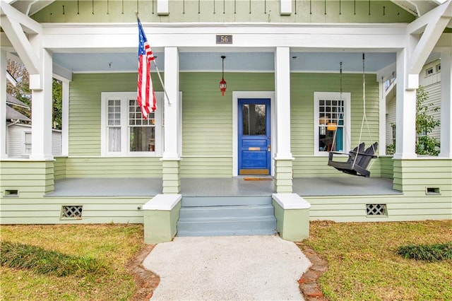 doorway to property with a porch and board and batten siding