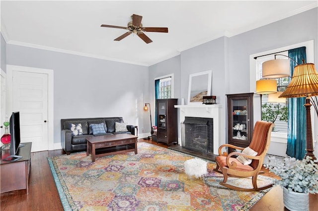 living room with crown molding, baseboards, and wood finished floors