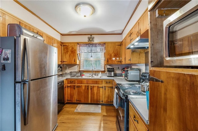 kitchen featuring ornamental molding, appliances with stainless steel finishes, sink, and light hardwood / wood-style flooring