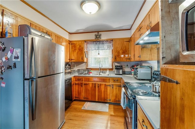 kitchen with ornamental molding, stainless steel appliances, sink, and light hardwood / wood-style flooring