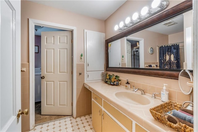 bathroom featuring tile walls, vanity, and curtained shower