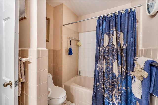 bathroom with tile walls, shower / tub combo, and toilet