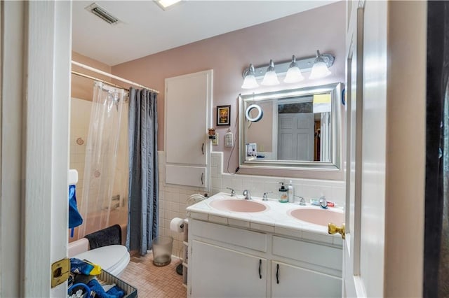 full bathroom featuring shower / tub combo with curtain, tile walls, tile patterned flooring, vanity, and toilet