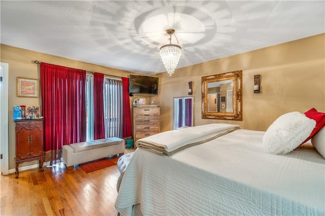 bedroom featuring hardwood / wood-style flooring and a notable chandelier