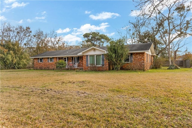 ranch-style home with covered porch and a front yard