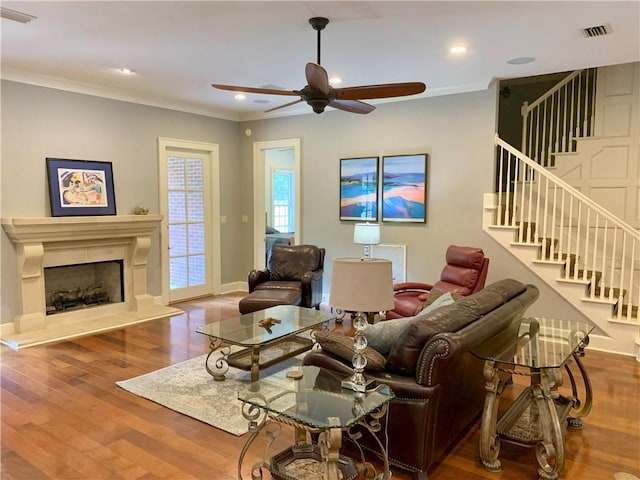 living room with ceiling fan, ornamental molding, and hardwood / wood-style flooring