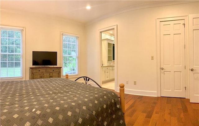 bedroom with multiple windows, hardwood / wood-style flooring, and ensuite bathroom