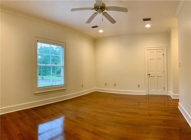 spare room featuring crown molding, dark wood-type flooring, and ceiling fan