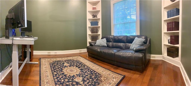 sitting room featuring built in features and wood-type flooring