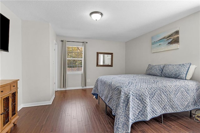 bedroom featuring a textured ceiling, baseboards, and wood-type flooring