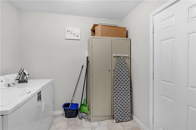 clothes washing area featuring washer and dryer, laundry area, baseboards, and a textured ceiling