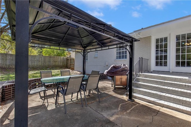 view of patio / terrace with a gazebo, outdoor dining space, and fence