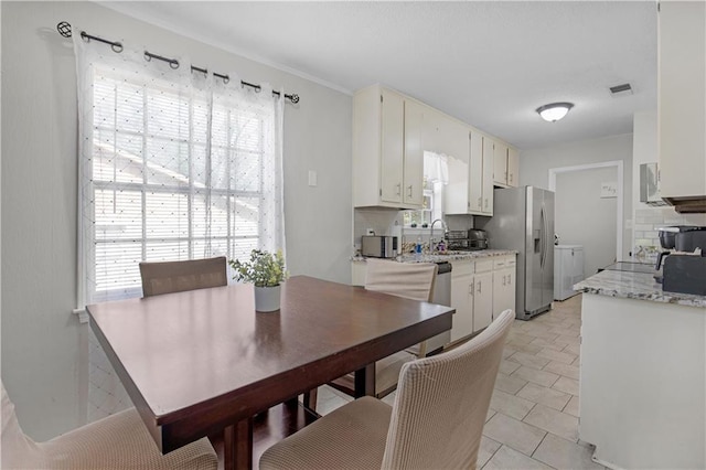 dining space featuring visible vents and washer and clothes dryer