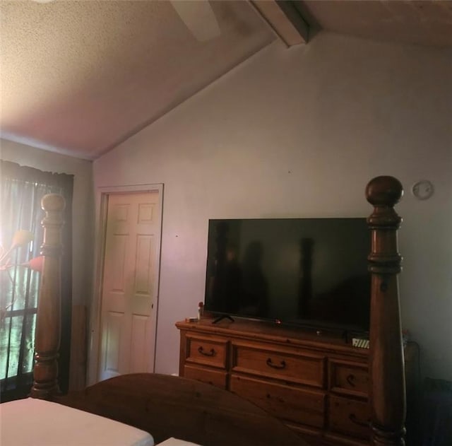 bedroom featuring a textured ceiling and lofted ceiling with beams