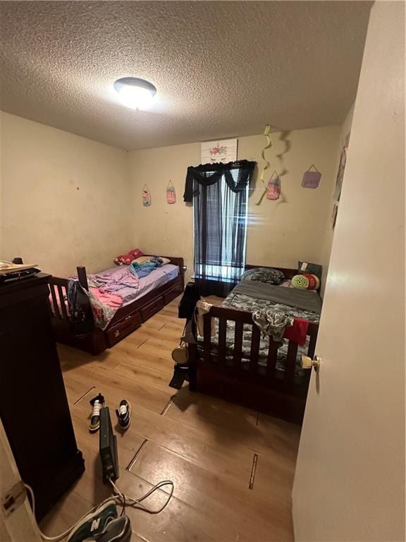 bedroom featuring wood-type flooring and a textured ceiling