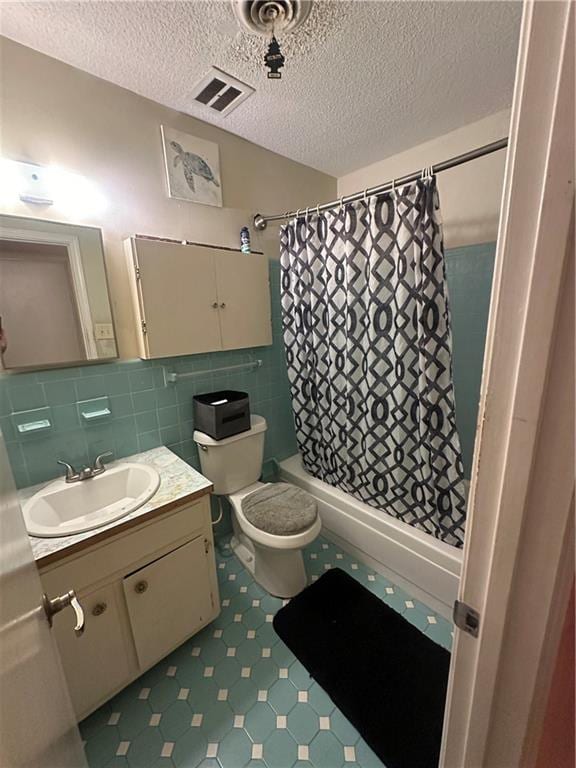 bathroom featuring a shower with curtain, a textured ceiling, vanity, and toilet