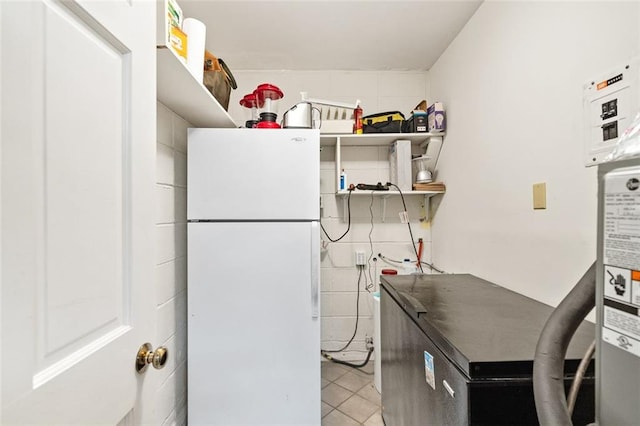 kitchen with stainless steel refrigerator, white fridge, and light tile flooring