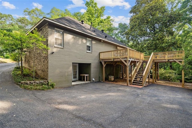 rear view of property featuring a wooden deck